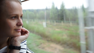 看着窗外享受着火车旅行的年轻女子的特写镜头27秒视频
