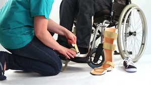 正在给轮椅上的年轻人带腿部矫形器29秒视频