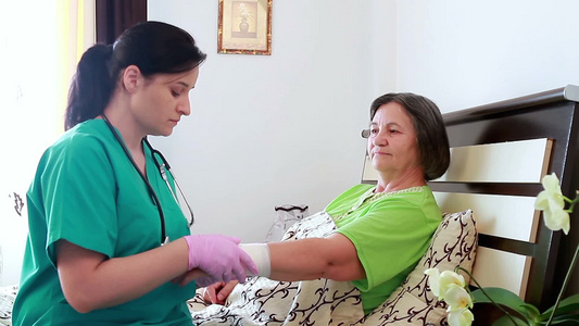 家庭保健护士包扎老年妇女的手腕视频