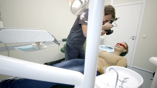 男性牙医拍摄的女性病人拍牙齿的全景照视频