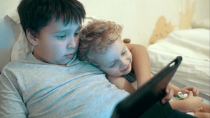 兄弟俩在床上使用平板电脑看电影7秒视频