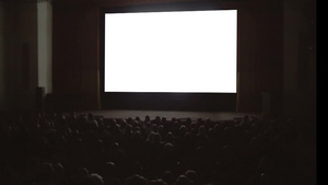 在大空白屏幕前的黑暗电影院大厅里观众的后视图59秒视频