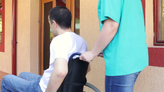 护士推着散步回来坐轮椅的年轻人视频