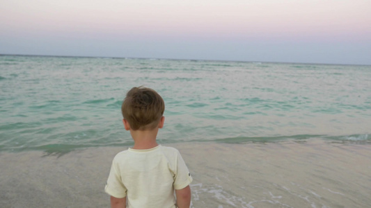 一个小男孩独自在海滩边视频