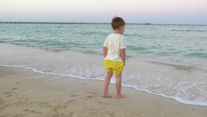 小男孩赤脚站在海边26秒视频
