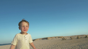 小男孩快乐地在沙滩上跑着67秒视频