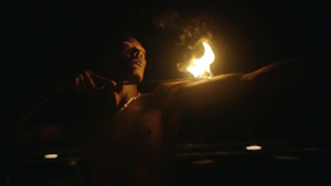 深色皮肤的男子把燃烧的火炬放在他的手臂和身体上在做表演22秒视频
