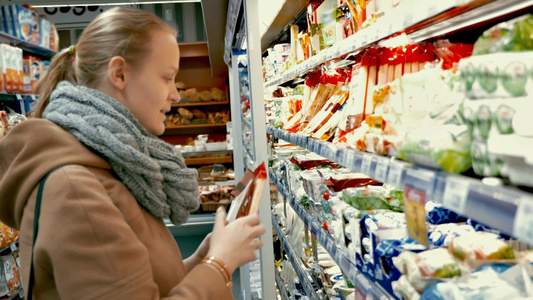 超市里的年轻女人在看每种产品的包装再做出选择视频