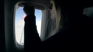 飞机上的女人打开窗户看向窗外20秒视频