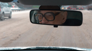 戴眼镜的老人在下雪天开车18秒视频