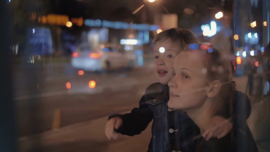 年轻的女子和小男孩在公交车等公交车视频