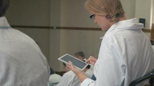 女医学生在礼堂的演讲会议上使用数字平板电脑上打字10秒视频
