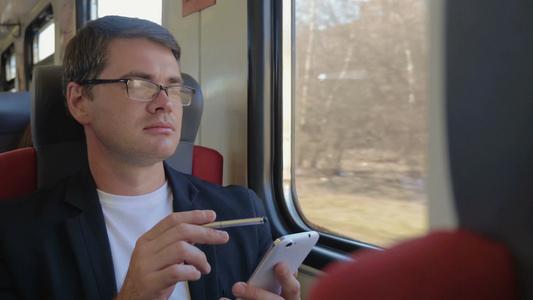 年轻白领在火车上用智能手机浏览互联网视频