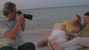在海滩上拍照片的年轻夫妇和小男孩18秒视频