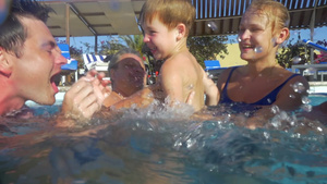 一个小男孩在游泳池里和父母和祖父母玩玩具的慢动作。 家庭乐趣在水上避暑胜地52秒视频