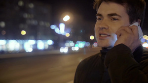夜晚年轻男子站在马路边打电话24秒视频