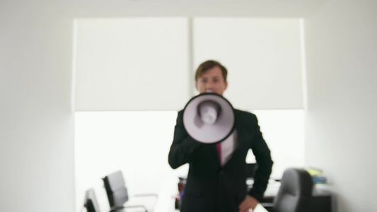 公司经理用扩音器大声站在现代办公室视频