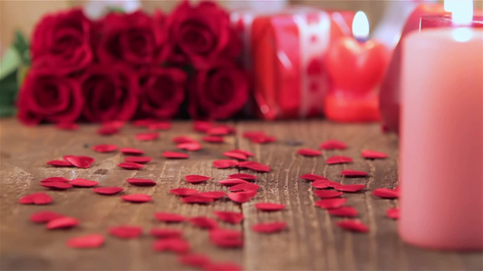 红色玫瑰礼品盒和蜡烛在木制背景上视频