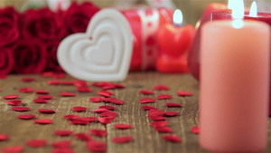 红色玫瑰和木制背景上的蜡烛21秒视频