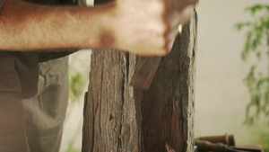 男性雕塑家用锤子和凿子在木头上雕刻14秒视频