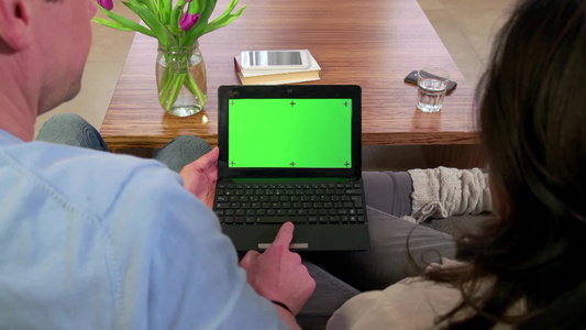 夫妇沙发上看笔记本电脑绿幕素材视频