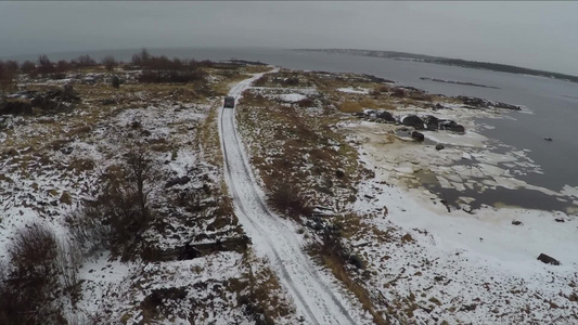 雪后行驶在俄罗斯索洛维茨基岸边上的汽车视频