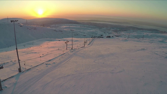 空中拍摄的遥远的滑雪胜地日落时美丽的自然景色视频