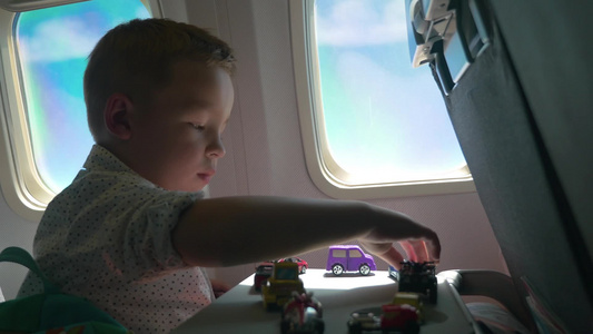 小男孩坐在飞机上玩玩具汽车视频
