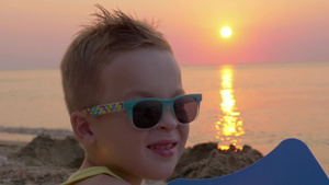 夕阳下戴着彩色太阳镜的金发小男孩14秒视频