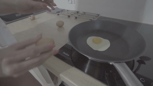 一个性感女人在厨房里用平底锅煎鸡蛋视频
