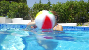 母亲和男孩在游泳池里玩气球6秒视频