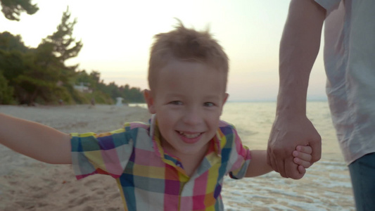 在海滩牵手玩耍的小男孩视频