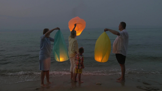 一家人晚上在海边放飞孔明灯视频
