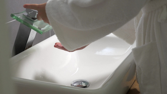 浴室里穿着白色长袍的女人洗手视频