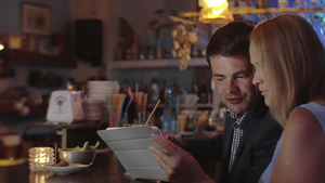 年轻的男人和女人在酒吧使用平板电脑交谈着工作事务7秒视频