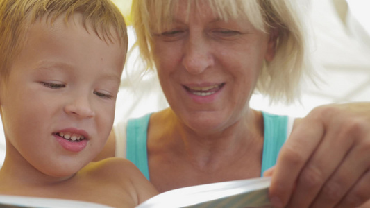 特写镜头一个小男孩听祖母读他的儿童书视频