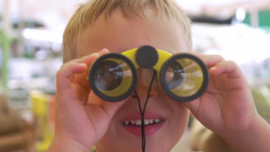 一个小男孩在玩双目望远镜视频