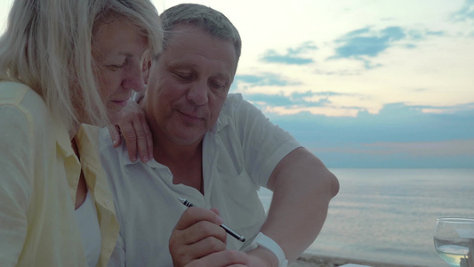 老年夫妇使用笔触摸智能手表视频
