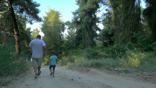 祖父和孙子在森林小路上慢跑视频