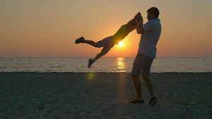 落日时父亲在海滩上和儿子玩耍19秒视频