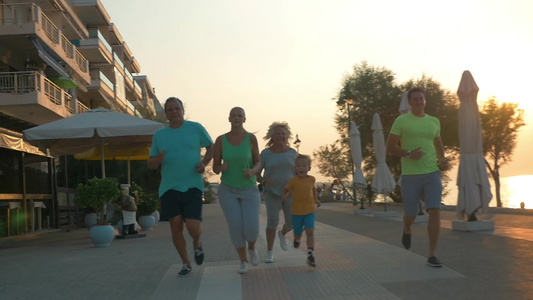 幸福大家庭在日落时沿着海边慢跑视频