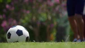 一个男人在绿草地上踢足球20秒视频