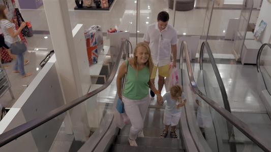 夫妇携带孩子商场购物乘电梯视频