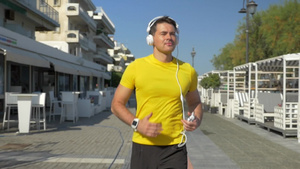 小镇上戴耳机的跑步的男人28秒视频