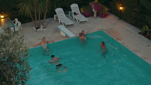 夜晚一家人在室外游泳池快乐地游泳玩耍的高角度镜头19秒视频