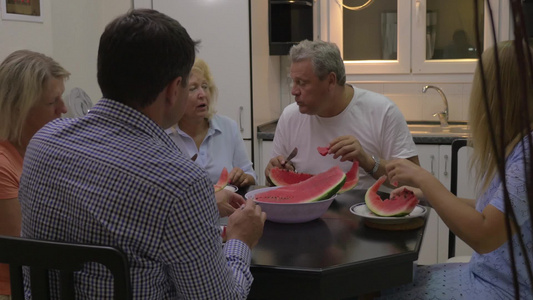 一家人坐在餐桌前吃西瓜视频