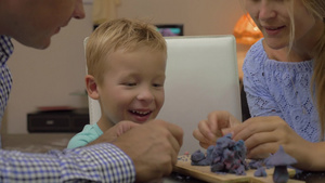年轻的父母和小儿子用橡皮泥捏造型玩得很开心35秒视频