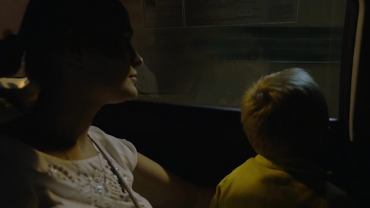 男孩和母亲坐在穿过隧道的车里视频