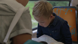 小男孩和妈妈坐在火车上在地图上搜索旅行目的地11秒视频