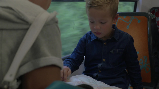 孩子和母亲乘火车时用地图检查旅行路线视频